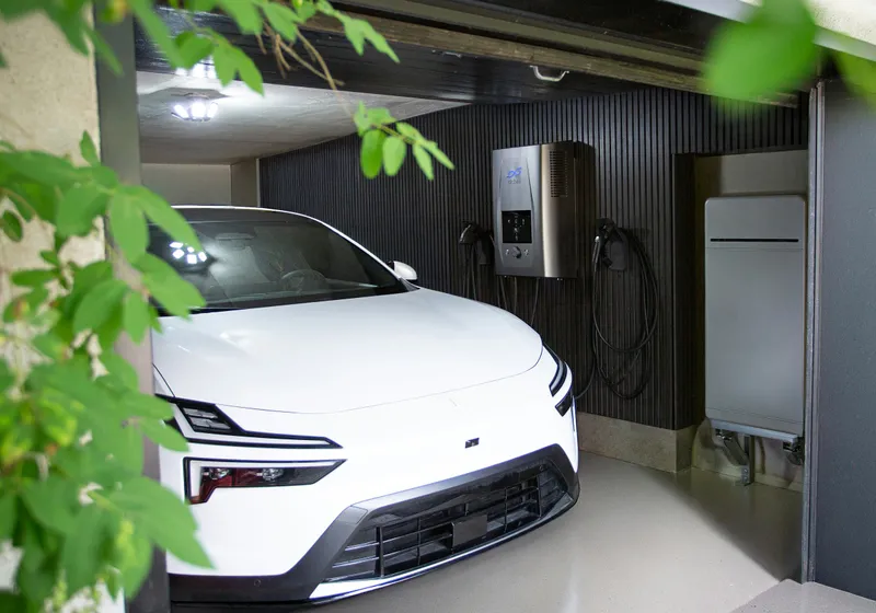 Elektrische auto die in de garage aan de laadpaal hangt