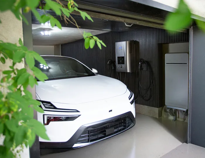 Elektrische auto die in de garage aan de laadpaal hangt